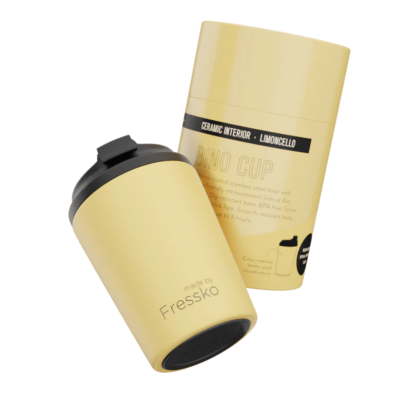 Yellow ceramic cup with black lid and 'Fressko' branding on a white background
