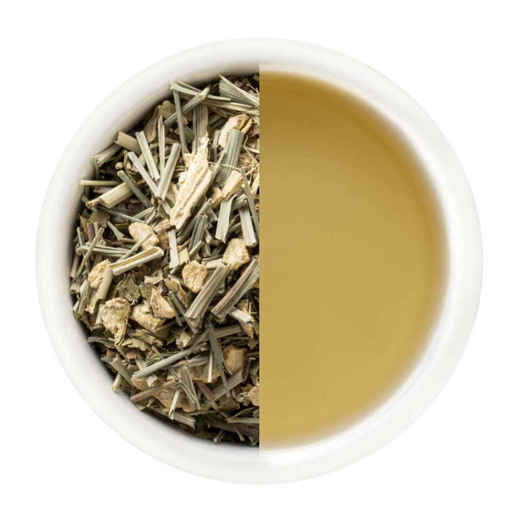 Tea leaves on one side and brewed tea on the other in a white bowl.