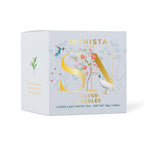 Light grey Silver Needles tea box with gold floral monogram design and a hummingbird illustration