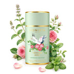 Persian Mint tea canister surrounded by pink roses and mint leaves on a white background