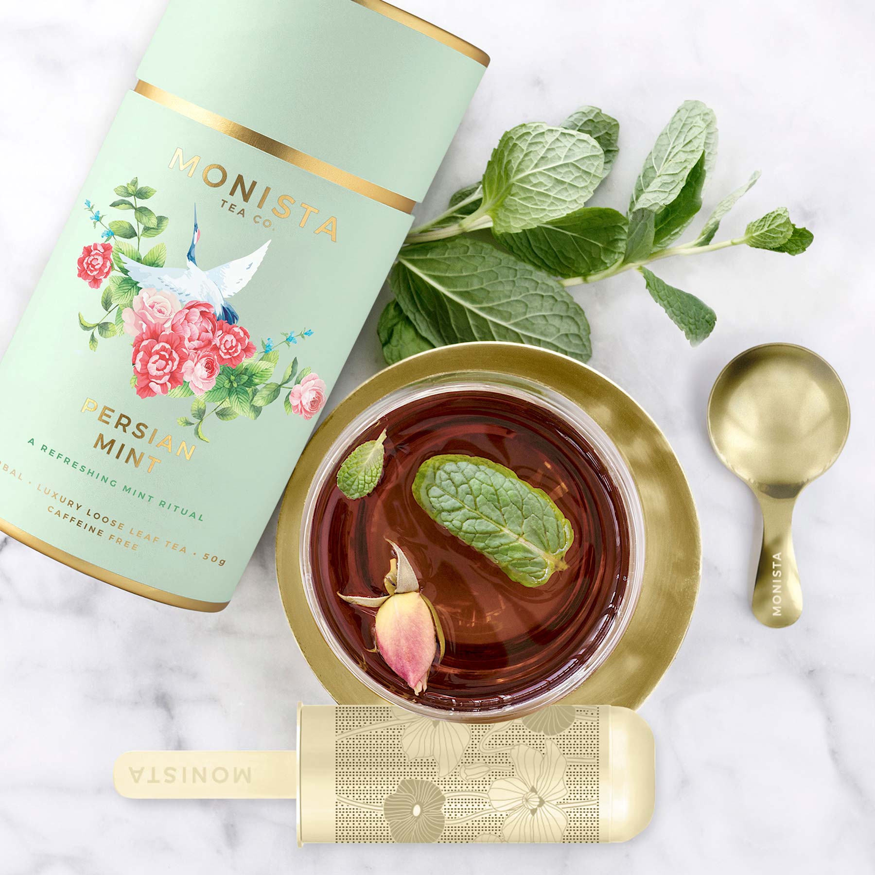 Persian Mint tea canister with fresh mint sprigs and a cup of tea garnished with mint and a rosebud