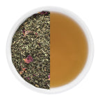 Tea leaves on one side and brewed tea on the other in a white bowl.