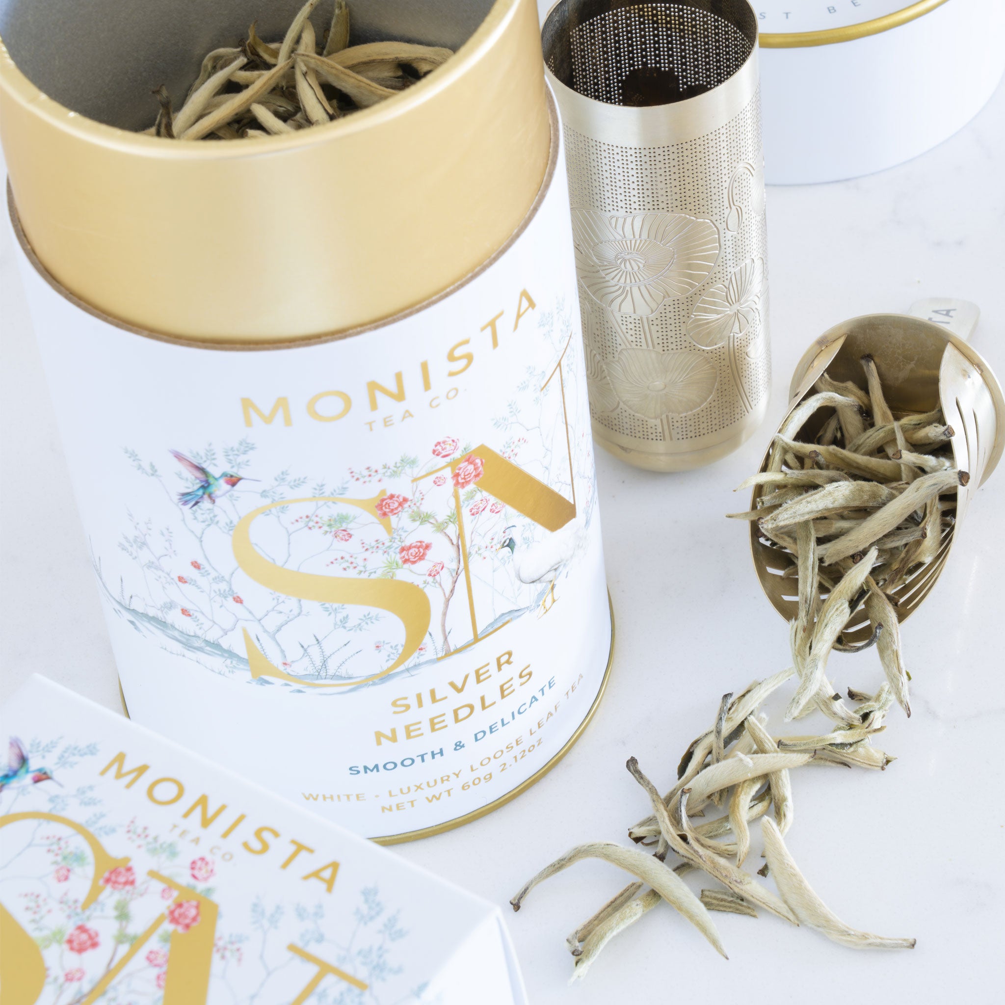 Monista tea canister with silver needle tea leaves on a white background