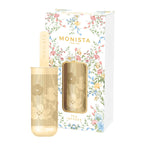 Gold mesh stick tea infuser with a floral pattern next to its Monista Tea Co packaging