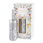 Silver mesh stick tea infuser with a floral pattern next to its Monista Tea Co packaging
