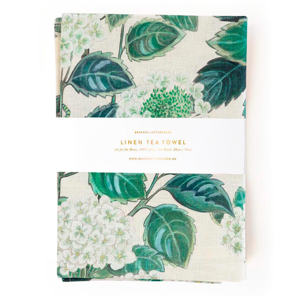 Folded linen tea towel with a hydrangea and leaf print in Bespoke Letterpress packaging
