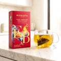 Very English Breakfast pyramid tea bag box with a rooster illustration next to a glass mug of brewed tea