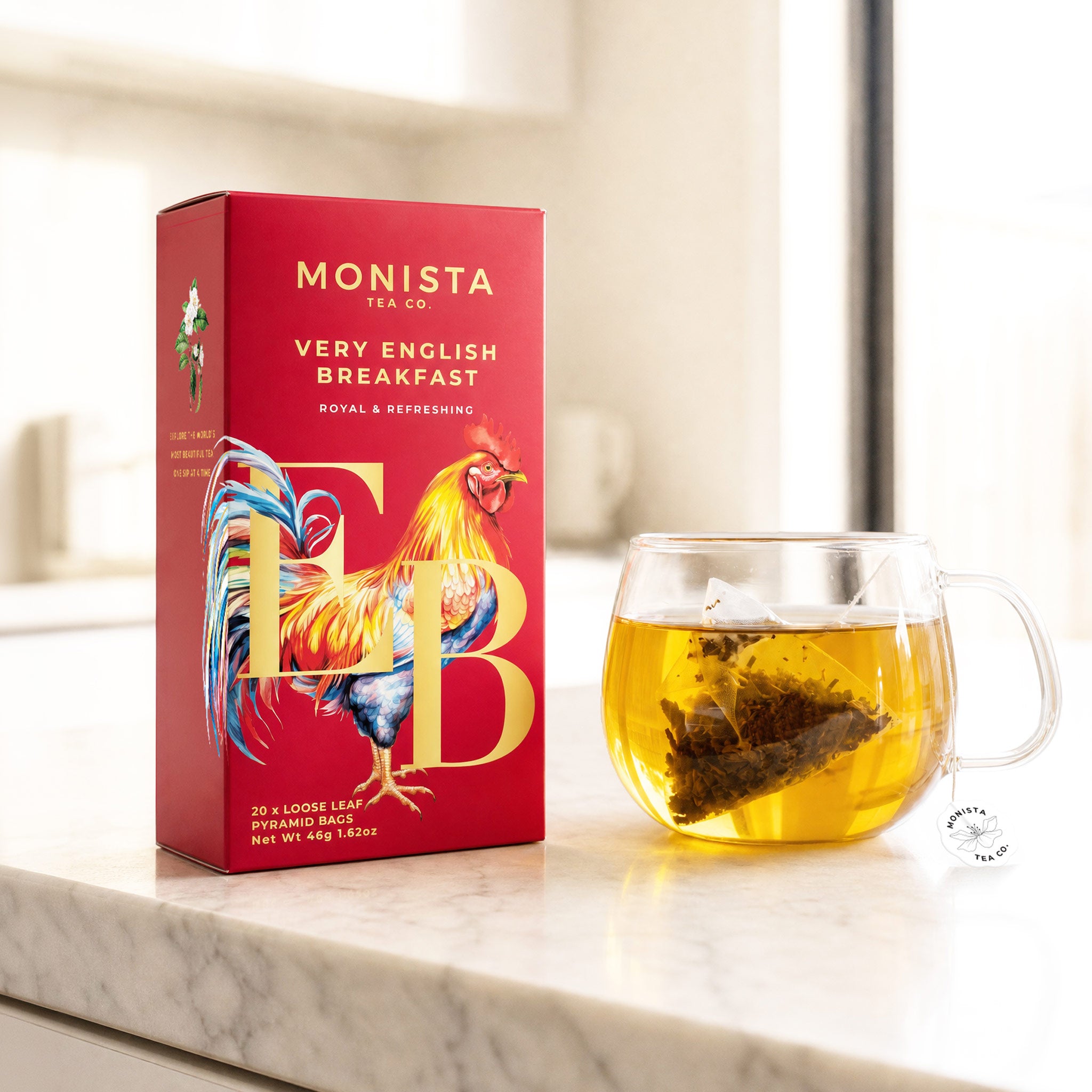 Very English Breakfast pyramid tea bag box with a rooster illustration next to a glass mug of brewed tea