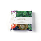 Folded reusable shopping bag with a purple floral print and 'made from recycled plastic bottles' tag