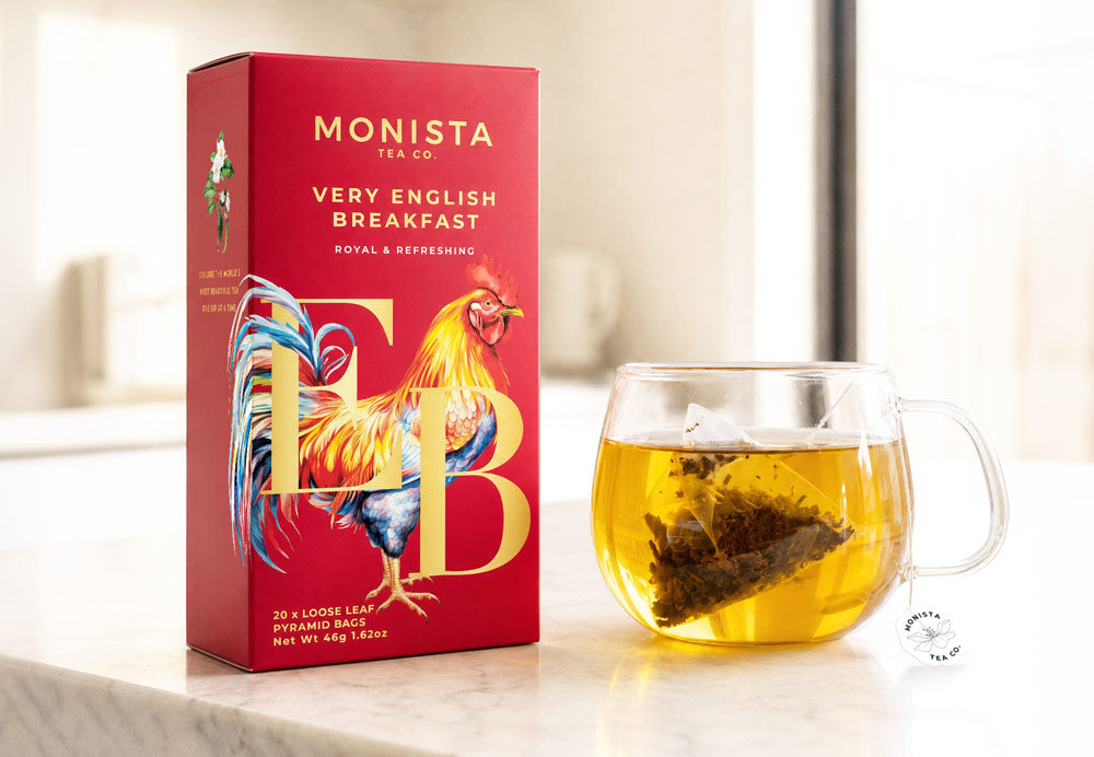 Very English Breakfast pyramid tea bag box next to a glass mug of brewed tea with a tea bag steeping