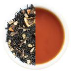 Tea leaves on one side and a cup of brewed tea on the other side.