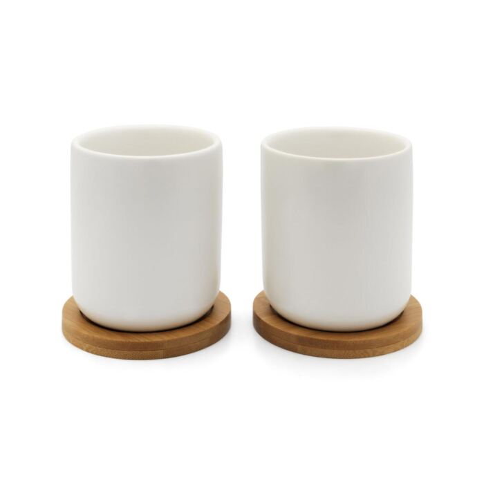 two white tea mugs on wooden coasters