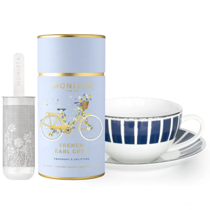 French Earl grey tea canister with blue tea cup and saucer and silver stick infuser