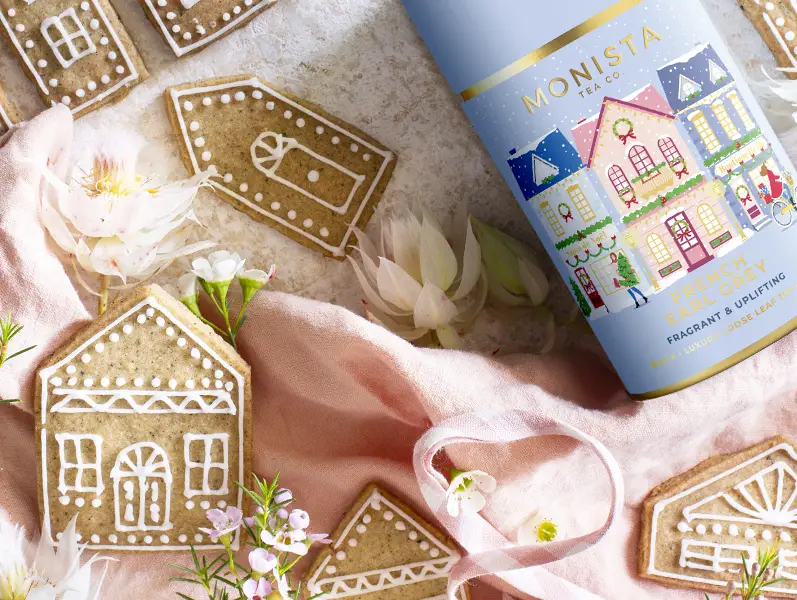 pretty photograph of little christmas biscuits in the shape of houses with flowers and tea canister