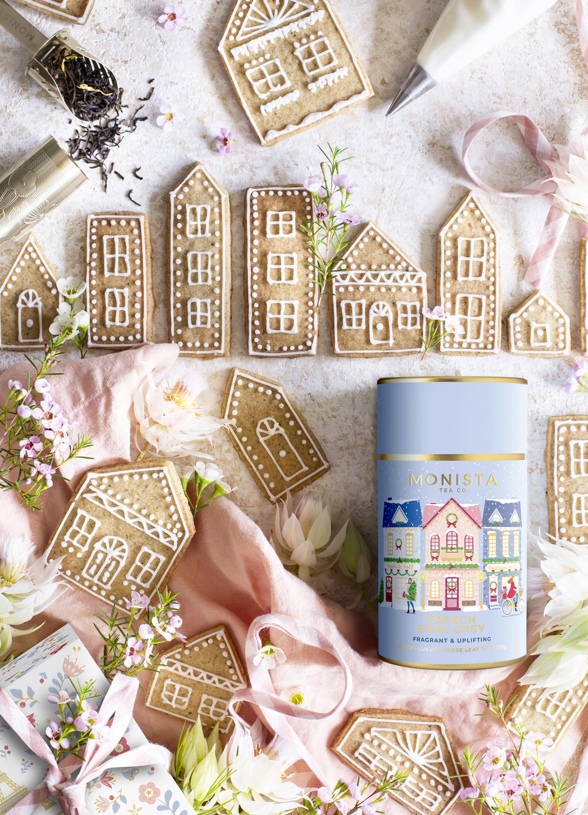 pretty photograph of little christmas biscuits in the shape of houses with flowers and tea canister